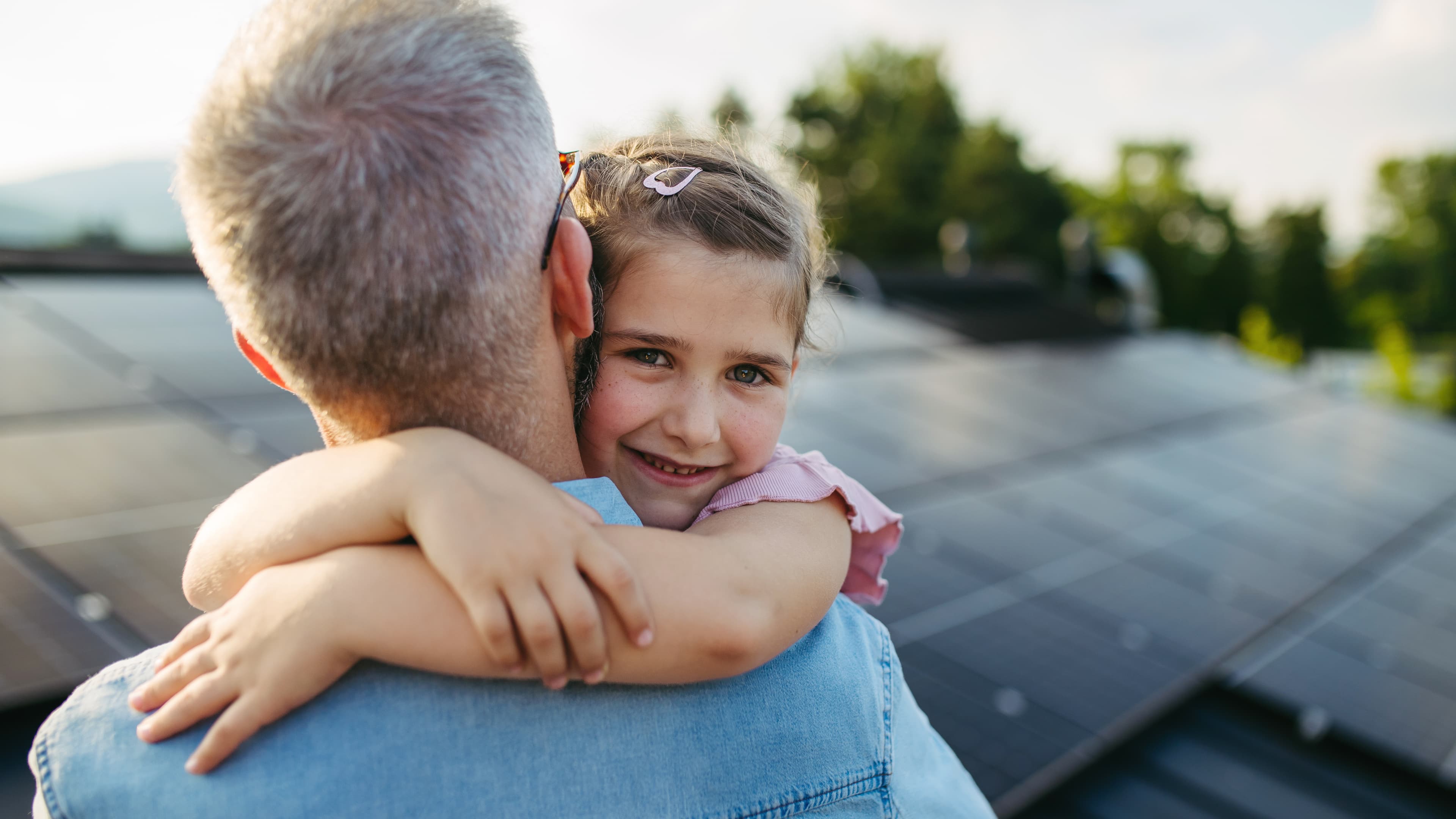 Vater mit Tochter im Hintergrund ein Dach mit Solarpanels